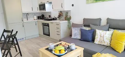 a living room with a couch and a table at Modern 2 BR Apartment near Town in Newmarket