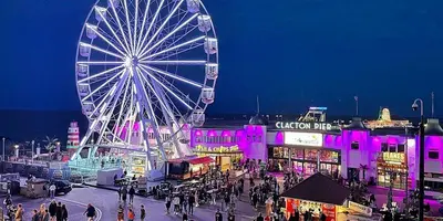 a large ferris wheel in a city with a crowd of people at 8 Bed Sun Decked Caravan Unlimited High speed Wifi and fun at Seawick Holiday Park in Clacton-on-Sea