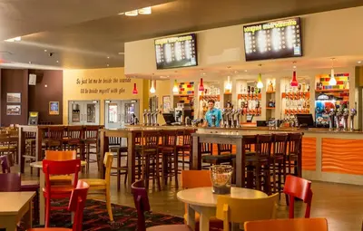 a restaurant with tables and chairs and a bar at 8 Bed Sun Decked Caravan Unlimited High speed Wifi and fun at Seawick Holiday Park in Clacton-on-Sea