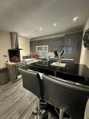a kitchen with black counter chairs and a stove at Bond Street Luxury Apartment Central Chelmsford in Chelmsford