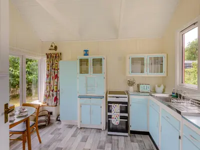 a kitchen with blue cabinets and a white refrigerator at Mahalia in Fordham