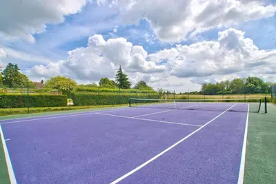 a tennis court with a purple tennis court at Ashfield Place Farm by Group Retreats in Stowmarket