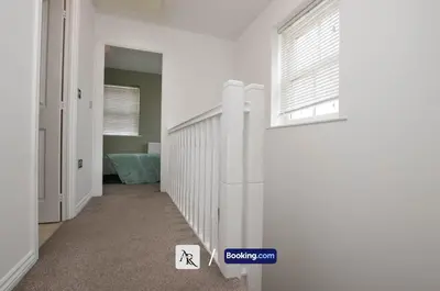a hallway with white walls and a window at Cozy House By AR Properties Short Lets & Serviced Accommodation Colchester in Colchester