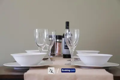 a table with plates and wine glasses on it at Cozy House By AR Properties Short Lets & Serviced Accommodation Colchester in Colchester
