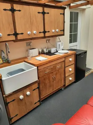 a kitchen with wooden cabinets and a sink at Mildenhall Suffolk in Mildenhall
