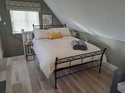 a bedroom with a large bed with pillows on it at Suffolk View Apartment in Tuddenham