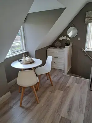 a dining room with a table and two chairs at Suffolk View Apartment in Tuddenham