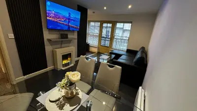 a living room with a couch and a table and a tv at 2 Bedroom Flat Ground Floor Town Centre Colchester in Colchester