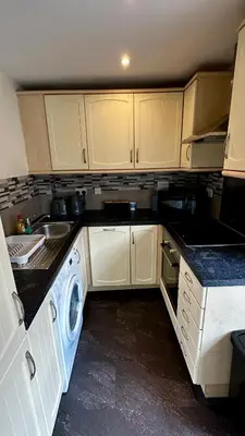 a kitchen with white cabinets and a washing machine at 2 Bedroom Flat Ground Floor Town Centre Colchester in Colchester