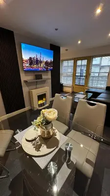 a living room with a table and a tv at 2 Bedroom Flat Ground Floor Town Centre Colchester in Colchester