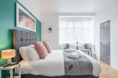a bedroom with a large bed and a table at The Modern Cambridge Studio 1 in Chesterton