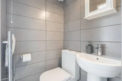 a bathroom with a white toilet and a sink at The Modern Cambridge Studio 1 in Chesterton
