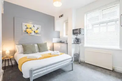 a bedroom with a bed and a kitchen at The Modern Cambridge Studio 2 in Chesterton