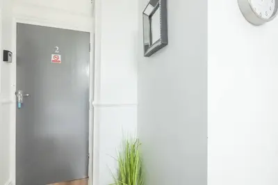 a hallway with a door and a clock on the wall at The Modern Cambridge Studio 2 in Chesterton