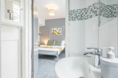 a bathroom with a sink and a bedroom with a bed at The Modern Cambridge Studio 2 in Chesterton