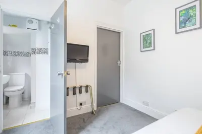 a bathroom with a toilet and a tv on the wall at The Modern Cambridge Studio 2 in Chesterton