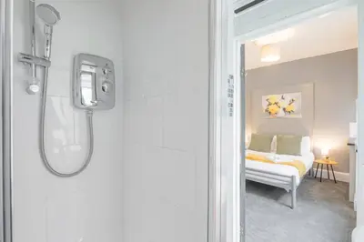 a bathroom with a shower and a bed in a room at The Modern Cambridge Studio 2 in Chesterton