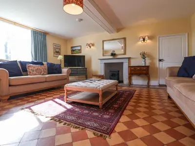 a living room with a couch and a coffee table at South Grange House - Sleep 16 in Saxmundham
