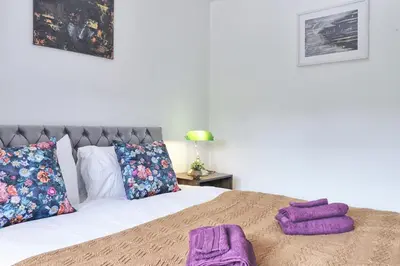 a bedroom with a bed with purple towels on it at Stylish 3 bedroom House In Grt Gregorie Basildon & Essex - Free Wifi, Parking, Dedicated Office & Private Garden in Basildon