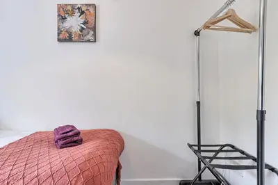 a bedroom with a bed with a pink blanket and a lamp at Stylish 3 bedroom House In Grt Gregorie Basildon & Essex - Free Wifi, Parking, Dedicated Office & Private Garden in Basildon