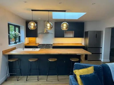 a kitchen with a large island with bar stools at 3 bed luxury open plan living in Rayleigh
