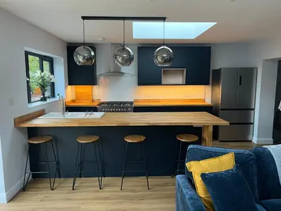 a kitchen with a large island with bar stools at 3 bed luxury open plan living in Rayleigh