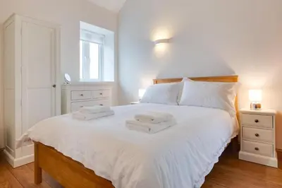 a bedroom with a large white bed with towels on it at 1 Bed in Quidenham oc-2233 in Quidenham