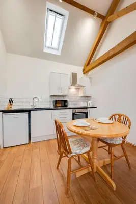 a kitchen with a wooden table and chairs at 1 Bed in Quidenham oc-2233 in Quidenham
