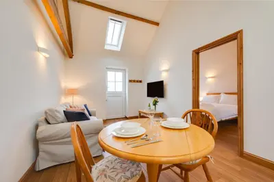 a living room with a table and a couch at 1 Bed in Quidenham oc-2233 in Quidenham