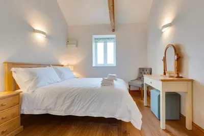 a bedroom with a bed and a desk and a mirror at 1 Bed in Quidenham oc-2232 in Quidenham