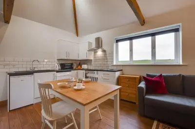 a kitchen and living room with a table and a couch at 1 Bed in Quidenham oc-2232 in Quidenham
