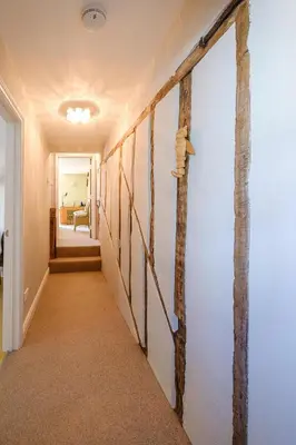 a hallway with a white wall with a pole at Crew Quarters in Aldeburgh