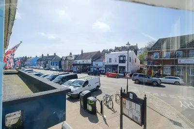 a city street with cars parked in a parking lot at Crew Quarters in Aldeburgh