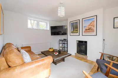 a living room with a couch and a fireplace at Frogmore Cottage in Leiston