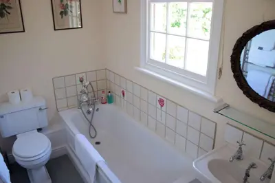 a bathroom with a tub and a toilet and a sink at The Old Rectory, Kettlebaston in Lavenham