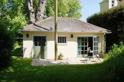 a small white house with a patio in a yard at The Old Rectory, Kettlebaston in Lavenham