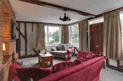 a living room with a red couch and a fireplace at The Red House Maldon in Maldon