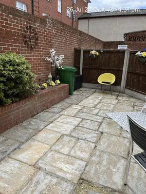 a patio with a yellow chair and a table at Beach Front House in Walton-on-the-Naze