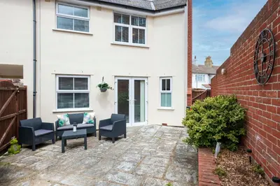 a patio in front of a white house at Beach Front House in Walton-on-the-Naze