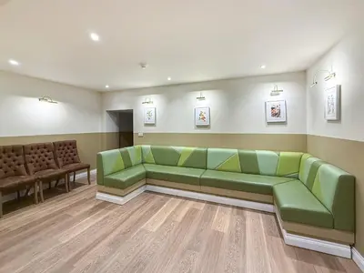 a waiting room with a green couch and chairs at Breckland Thatched Cottage in Hockwold cum Wilton