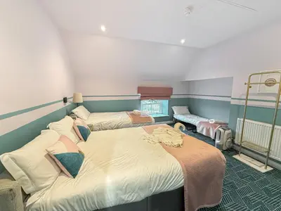 a room with two beds in a room at Breckland Thatched Cottage in Hockwold cum Wilton