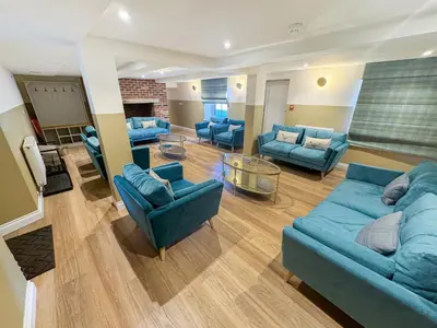 a large living room with blue couches and chairs at Breckland Thatched Cottage in Hockwold cum Wilton