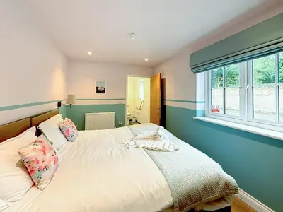 a bedroom with a bed and a window at Breckland Thatched Cottage in Hockwold cum Wilton