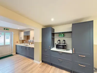 a kitchen with blue cabinets and a microwave at Breckland Thatched Cottage in Hockwold cum Wilton