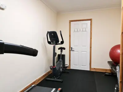 a room with a gym with a treadmill at The Forest House in Brandon