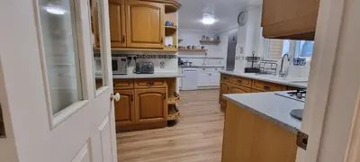 a kitchen with wooden cabinets and a counter top at The Forest House in Brandon