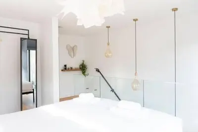 a white room with a mirror and a chair at Stylish Cambridge Home with free parking in Cambridge