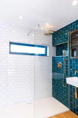 a bathroom with a glass shower with blue tiles at Stylish Cambridge Home with free parking in Cambridge