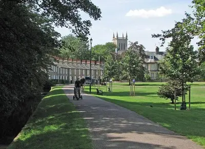a person riding a bike down a path in a park at Stylish Cambridge Home with free parking in Cambridge