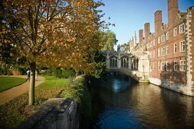 a bridge over a river in front of a building at Stylish Cambridge Home with free parking in Cambridge